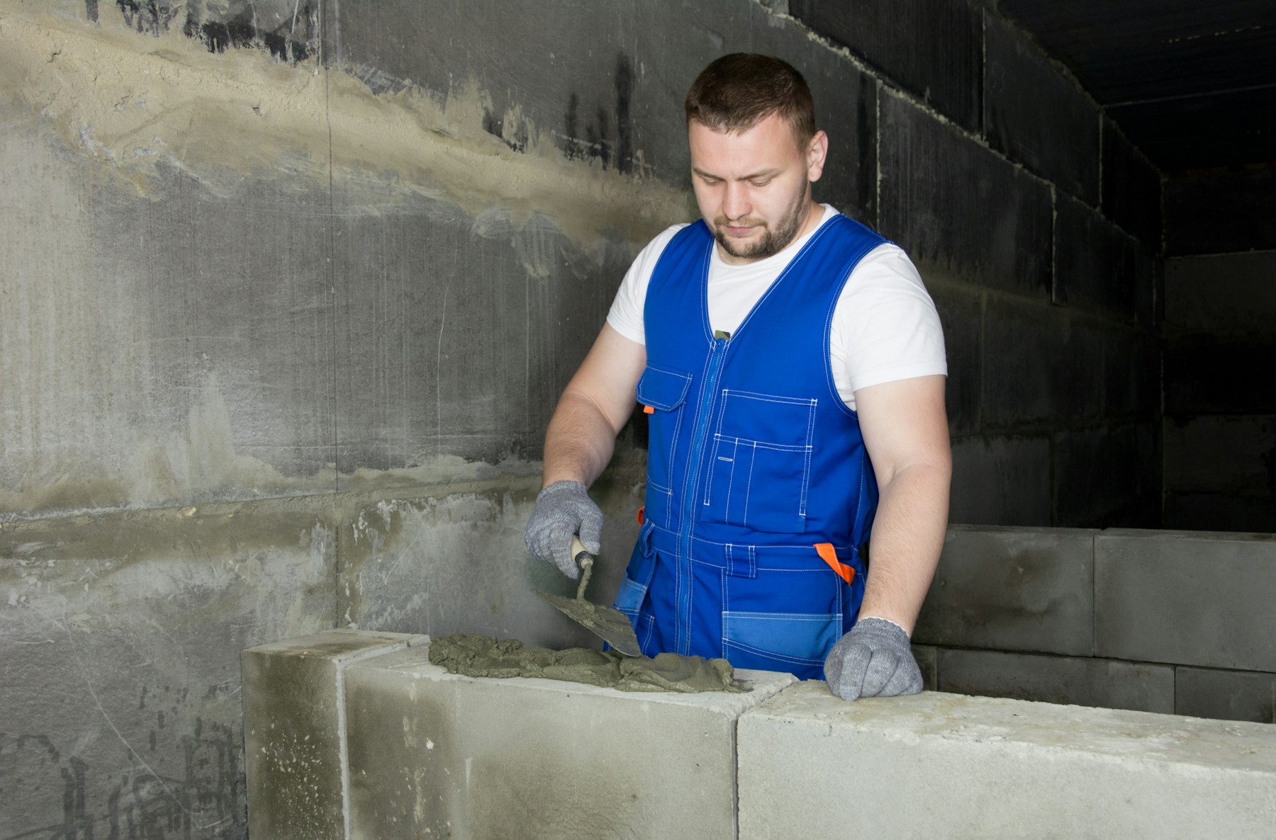 Albañil trabajando con llana y cemento en una obra